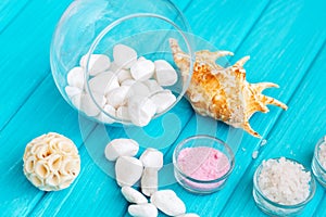 Sea Ã¢â¬â¹Ã¢â¬â¹salt in a glass white stones and Shell for spa and relaxation on a blue background